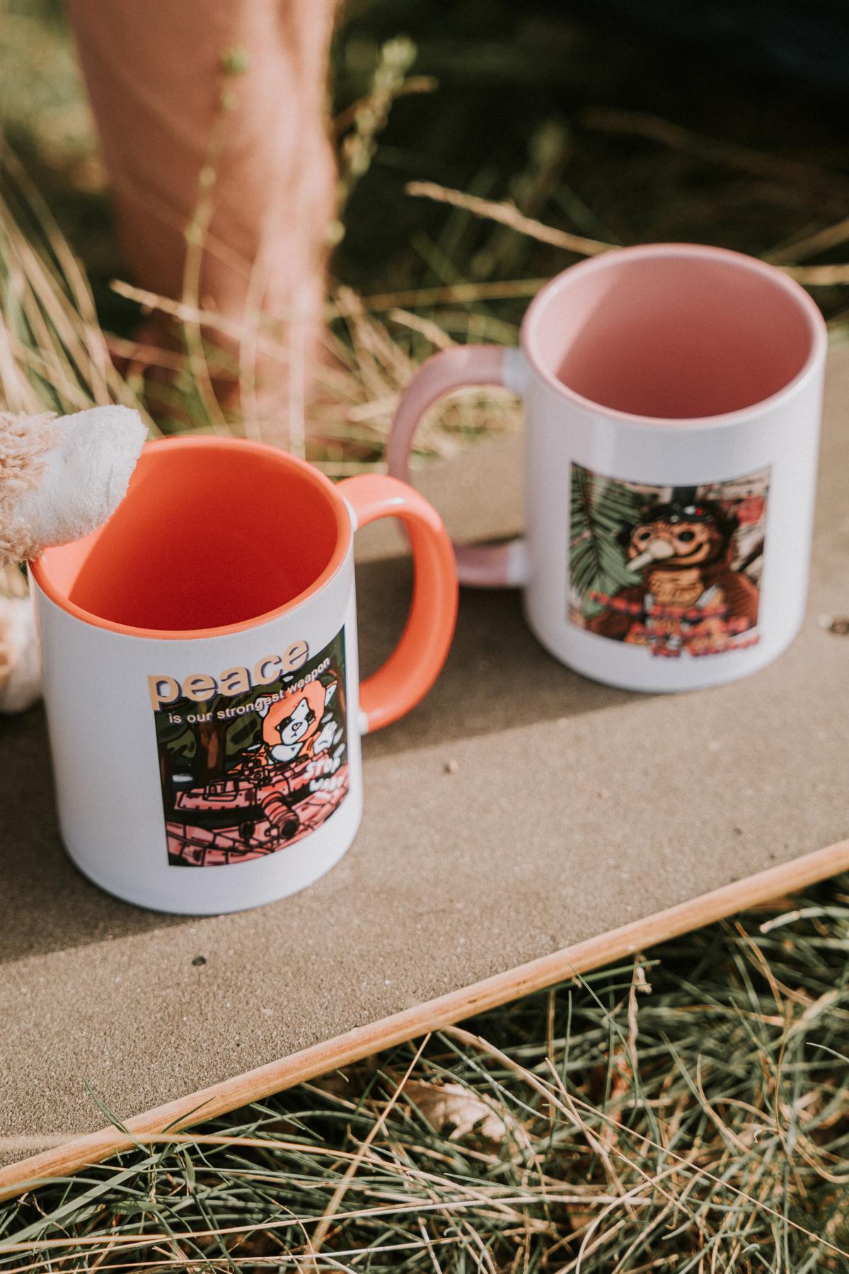 "Peace Is Our Strongest Weapon" – Weiße Tasse mit orangener Innenfarbe
